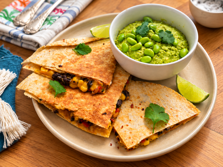 Quesadillas Tex-Mex de frijoles negros con cheddar acompañadas de crema de aguacate y edamame, lima y cilantro